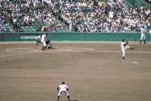 a baseball game is being played in front of a crowd with a sign that says ' a ' on it