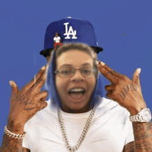 a man wearing a la dodgers hat and glasses