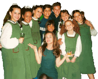 a girl in a green dress holds a glass in front of a group of children