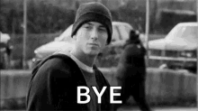 a black and white photo of a man wearing a hat and a hoodie with the words `` bye '' .