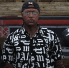 a man wearing glasses and a black hat with the word huj on it