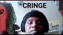 a man wearing headphones holds a toy gun in front of a screen that says " cringe "