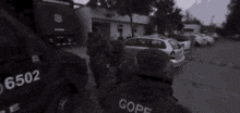 a black and white photo of a group of soldiers standing in front of a building .