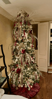 a christmas tree is decorated in red and gold