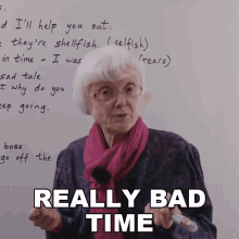 an elderly woman is standing in front of a white board and says really bad time