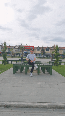 a man sits on a bench in front of a red sign that says ' istanbul ' on it