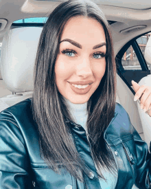 a woman sitting in the back seat of a car smiling