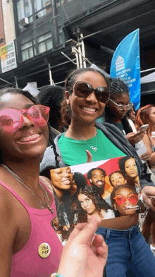 a woman wearing pink sunglasses holds a picture of a group of people