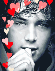 a close up of a man 's face with hearts surrounding it
