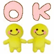 two yellow stuffed animals are holding hands under a pink polka dot letter ok .