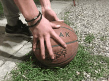 a person is holding a basketball with the letter ak on it