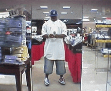 a man is taking a selfie in front of a mirror in a clothing store .