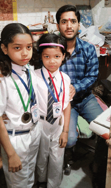 a man and two girls are posing for a picture and one of them has a medal around her neck