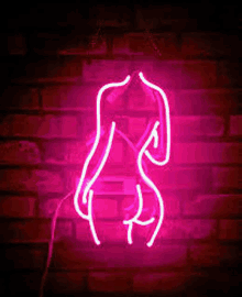 a neon sign of a woman 's torso against a brick wall .