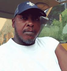 a man with a beard wearing a new orleans saints baseball cap