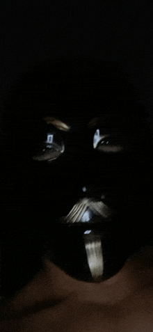 a close up of a person 's face with a black mask on it