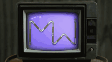 a tv with a purple screen and the letter m on it