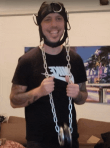 a man wearing a helmet and a nike shirt holds a chain around his neck