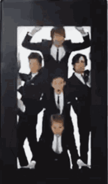 a group of men in suits are standing in a pyramid on a cell phone screen