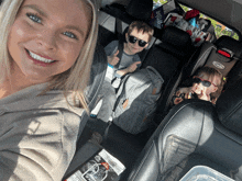 a woman is taking a selfie in the back seat of a car with two children in a graco car seat