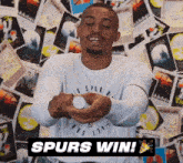 a man wearing a spurs shirt is holding a bottle in his hands