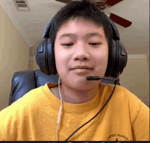 a boy wearing headphones and a yellow shirt that says unified school district