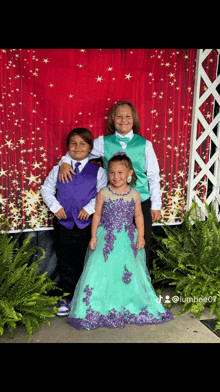 two boys and a little girl pose for a picture