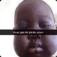 a close up of a baby 's face with a caption that says ' hvad glor du på din adem '