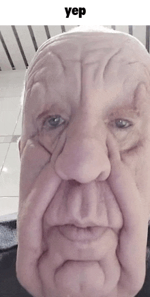 a close up of a man 's face with a large nose and a very wrinkled face .