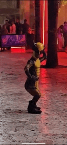 a person in a wolverine costume is standing on a sidewalk .