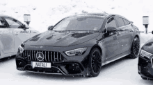 a mercedes amg gt 63 s coupe is parked in the snow next to a mercedes a class .