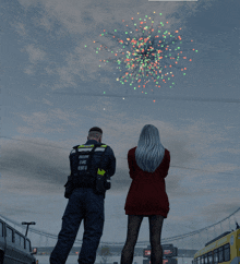 a man and a woman watching fireworks with the man wearing a vest that says ' tallinn eine '