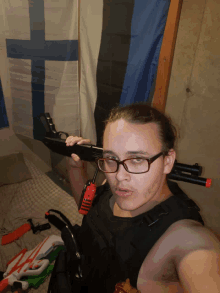 a man holding a gun in front of a flag