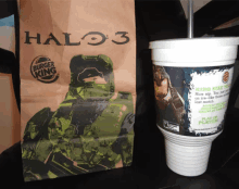 a halo 3 burger king bag next to a cup with a straw