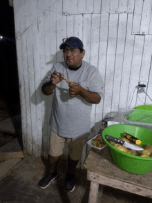 a man is standing in front of a wooden wall holding a piece of food