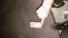 a person is pointing at a box of cigarettes that has the letter s on it