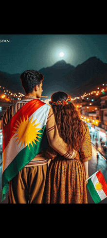 a man and a woman are standing next to each other with a kurdish flag .