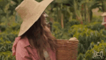 a woman in a straw hat is holding a basket in a field with nuestra tele written on the bottom