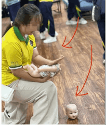 a woman in a yellow shirt holds a baby in her lap