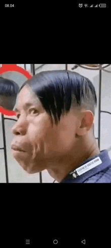 a man with a very short haircut is making a funny face in front of a mirror .