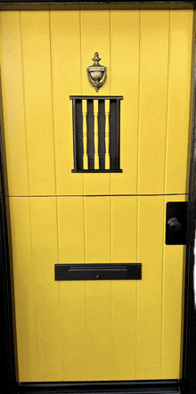 a yellow door with a brass door knocker