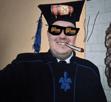 a man wearing a graduation cap and gown has a cigarette in his mouth and sunglasses that say devils pergunt