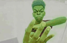 a man with green hair is holding a cell phone and making a hulk face .