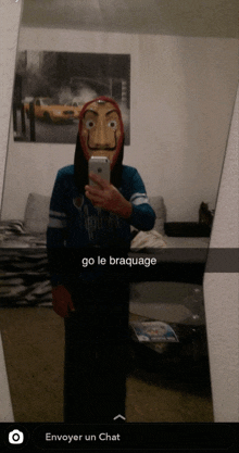 a person wearing a mask is taking a selfie in front of a mirror with the caption go le braquage