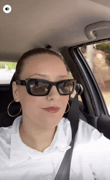 a woman wearing sunglasses is sitting in a car