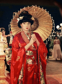 a woman in a red kimono holding a large umbrella