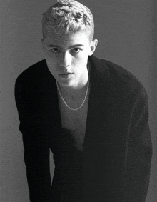 a black and white photo of a young man with blonde hair