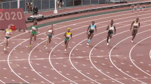 a group of women are running on a track with a sign that says women 's 200m in the background