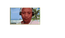 a man wearing headphones is sitting in front of a beach background .