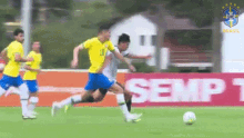 a group of soccer players are playing soccer on a field with a sign that says semp on it .